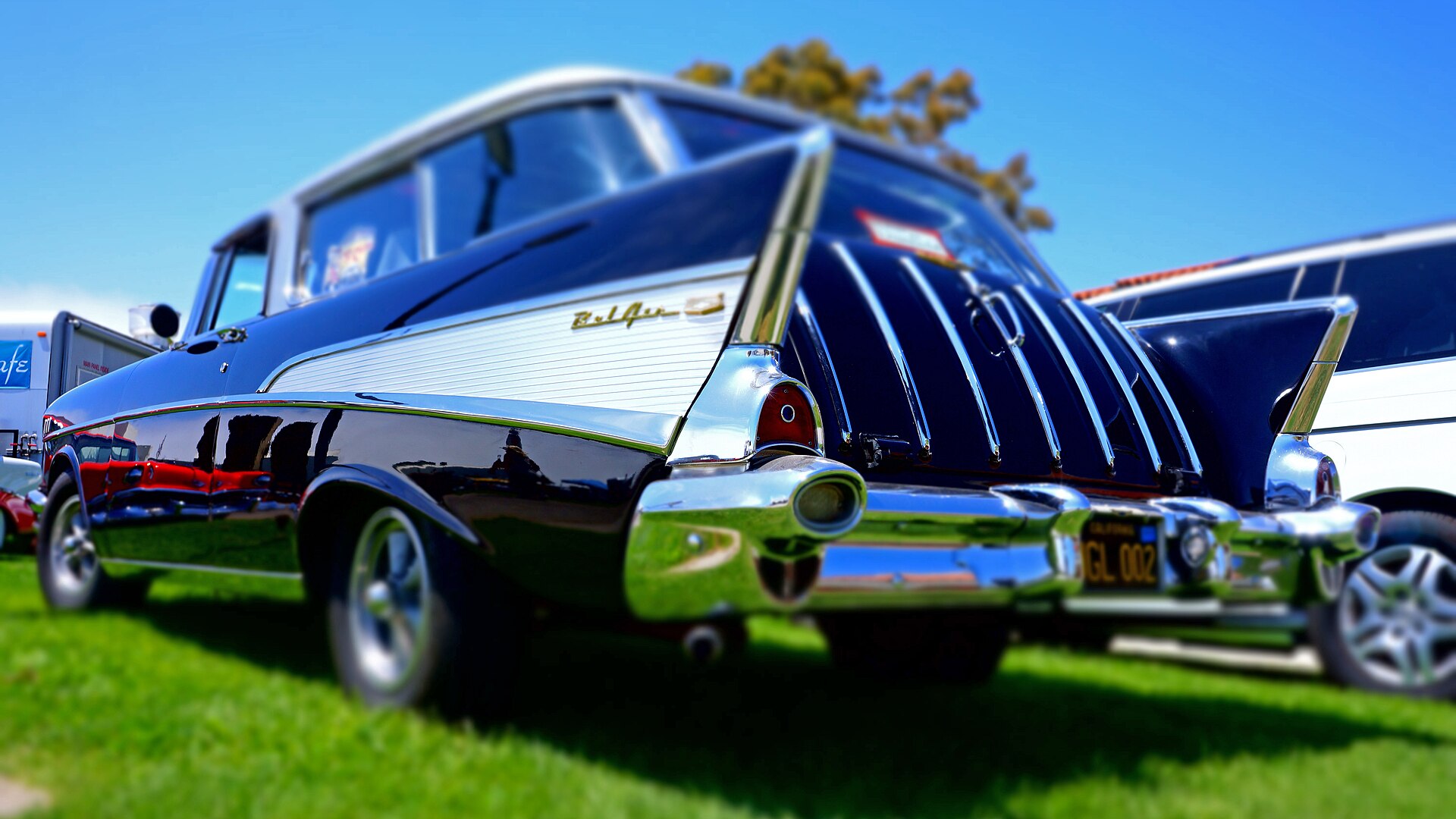 A 1957 rear fin with Bel Air script, among other parked cars.