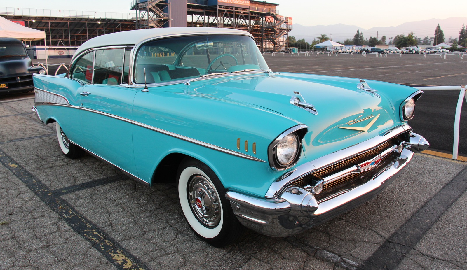 Modern photograph of a 1957 Bel Air two-door hardtop with a pale roof, blue-green body, full wheel covers and whitewall tires. Exact paint code unverified.